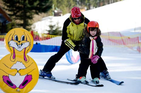 Lyžiarska škôlka - dieťa na lyžiach s inštruktorom