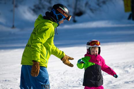 Dieťa na lyžiach s inštruktorom